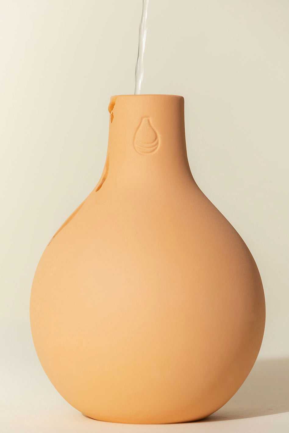 An Oya watering pot being refilled