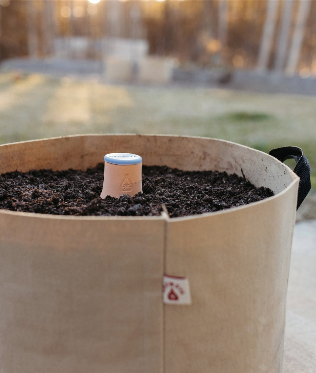 Oya™ Grow Bag filled with soil and an Oya™ Watering Pot